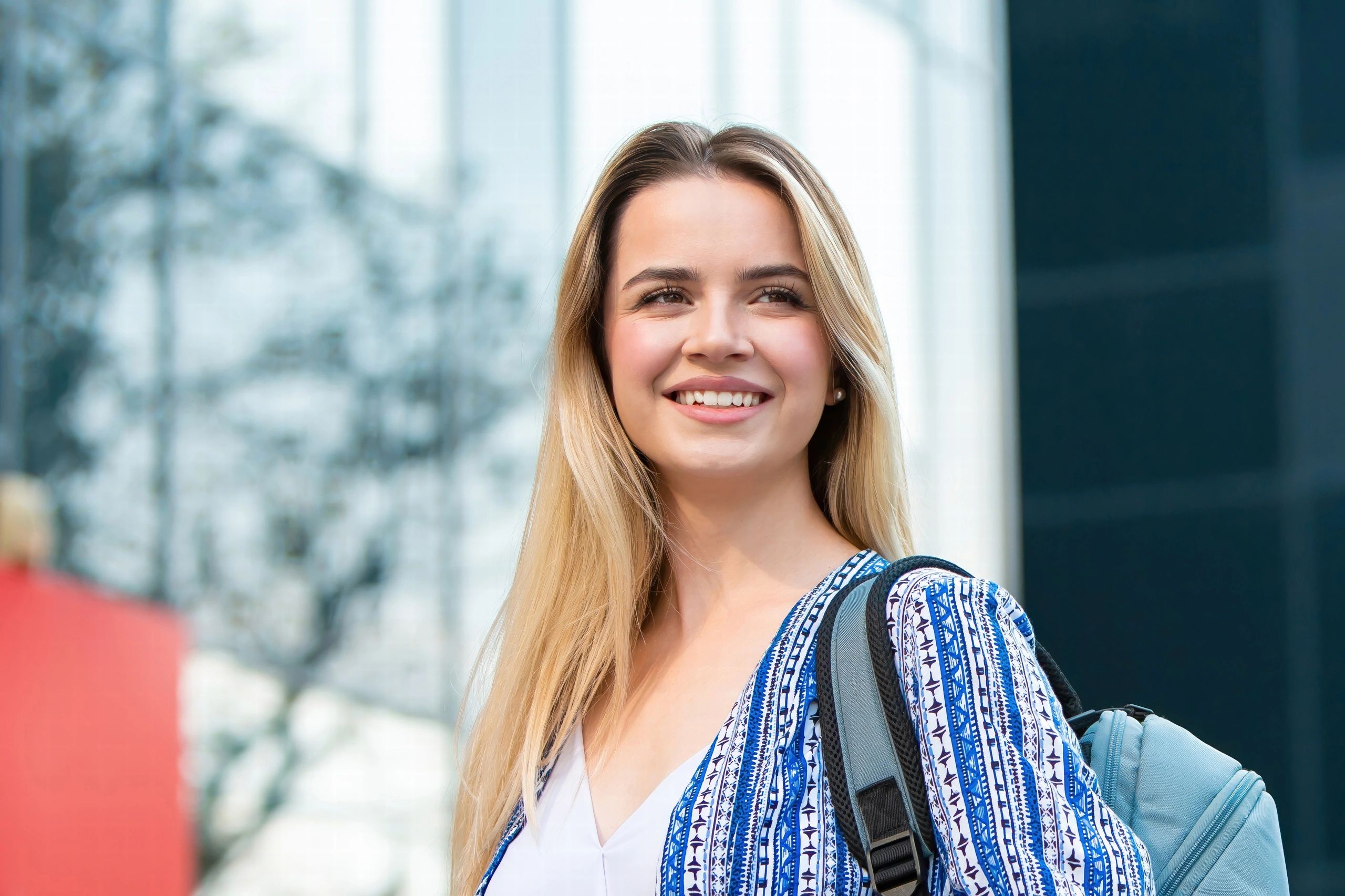 Estudante sorrindo em ambiente universitário moderno